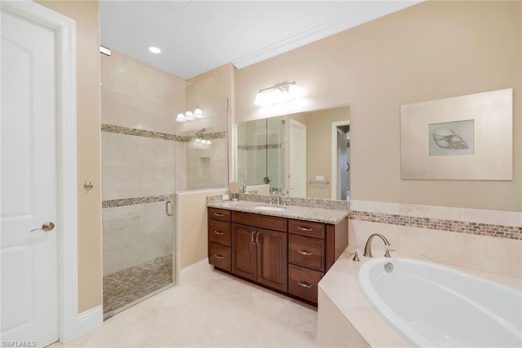 7598 Moorgate Point Way Naples, FL 34113 - Photo 14 of 33 a spacious bathroom with a tub sink shower and mirror