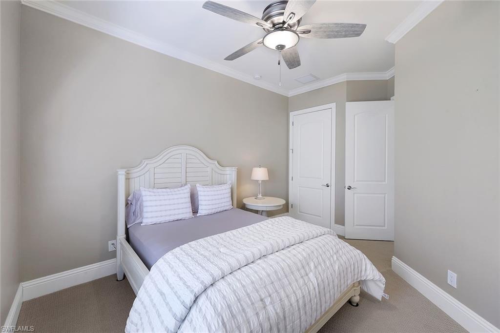 7598 Moorgate Point Way Naples, FL 34113 - Photo 17 of 33 a bedroom with a bed and a chandelier