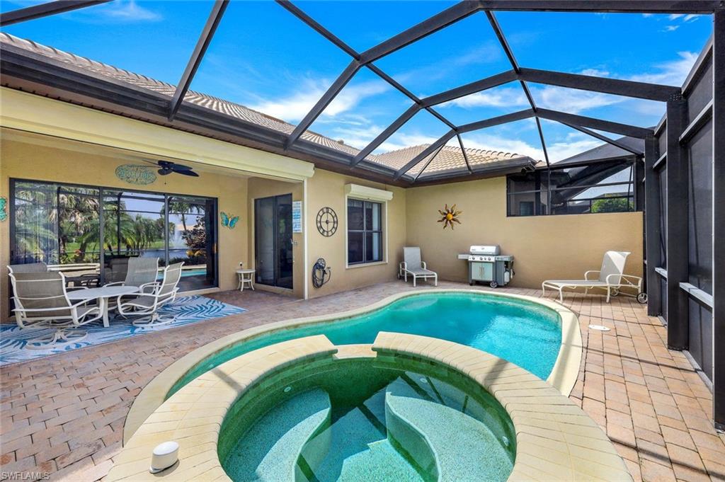 7598 Moorgate Point Way Naples, FL 34113 - Photo 25 of 33 a swimming pool with table and chairs