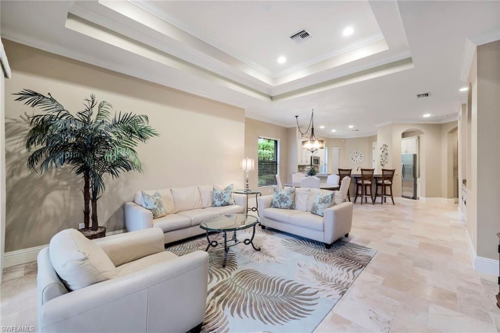 7598 Moorgate Point Way Naples, FL 34113 - Photo 4 of 33 a living room with furniture and a large mirror