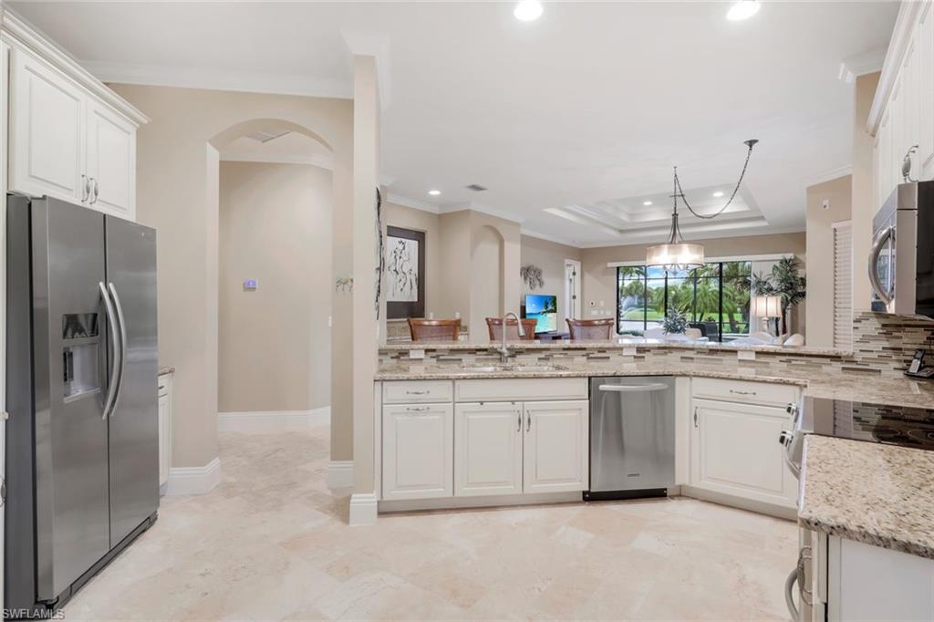 7598 Moorgate Point Way Naples, FL 34113 - Photo 8 of 33 a kitchen with granite countertop a sink and stainless steel appliances