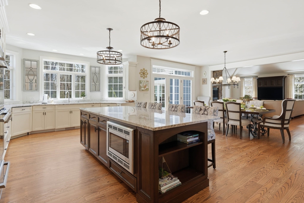 9 Ross Lane Middleton, MA 01949 - Photo 4 of 42 an open kitchen with granite countertop a stove and a sink
