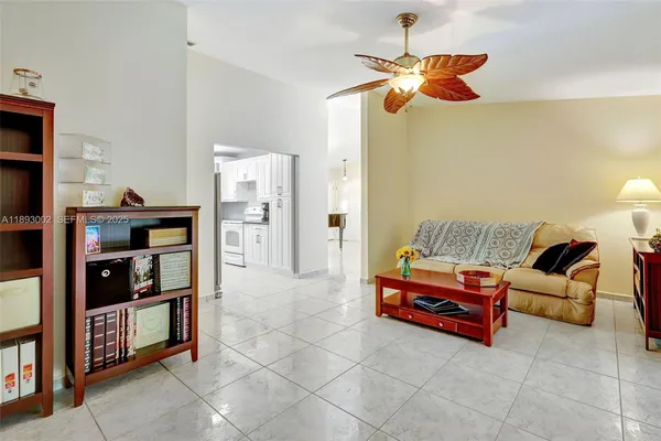 a living room with furniture a ceiling fan and a book shelf