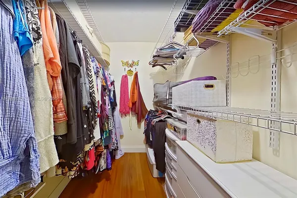 a view of walk in closet with clothes