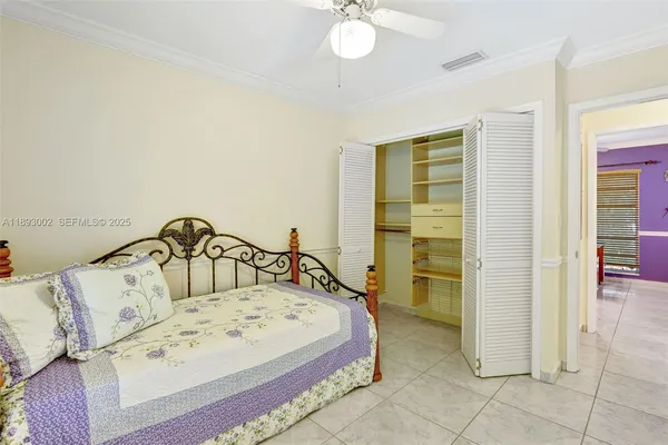a view of a bedroom with a bed and ceiling fan