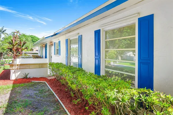 a front view of a house with a yard and potted plants