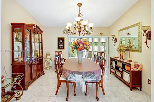a view of a dining room with furniture and a chandelier