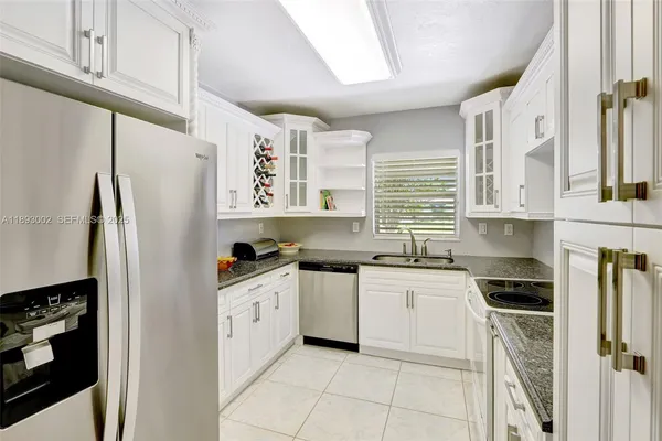 a kitchen with stainless steel appliances granite countertop a refrigerator and a stove