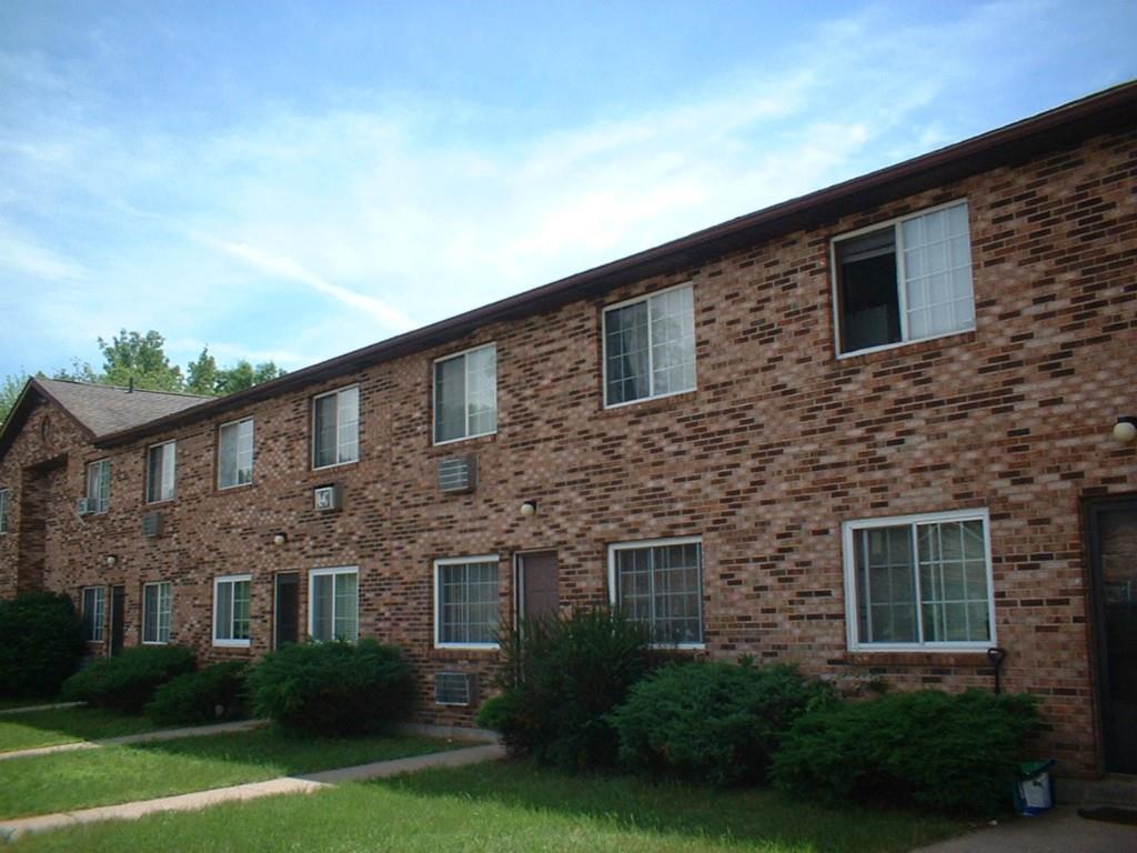 a brick house that has a lots of windows in it