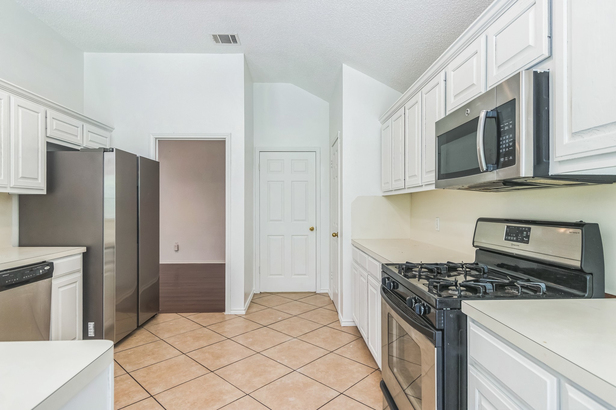 800 Mountain Ridge Drive Leander, TX 78641 - Photo 12 of 31 High ceilings and durable tile flooring highlight this functional kitchen space.