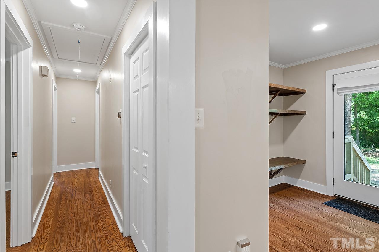 2609 Elmhurst Circle Raleigh, NC 27610 - Photo 15 of 34 a view of a hallway with wooden floor and a bathroom