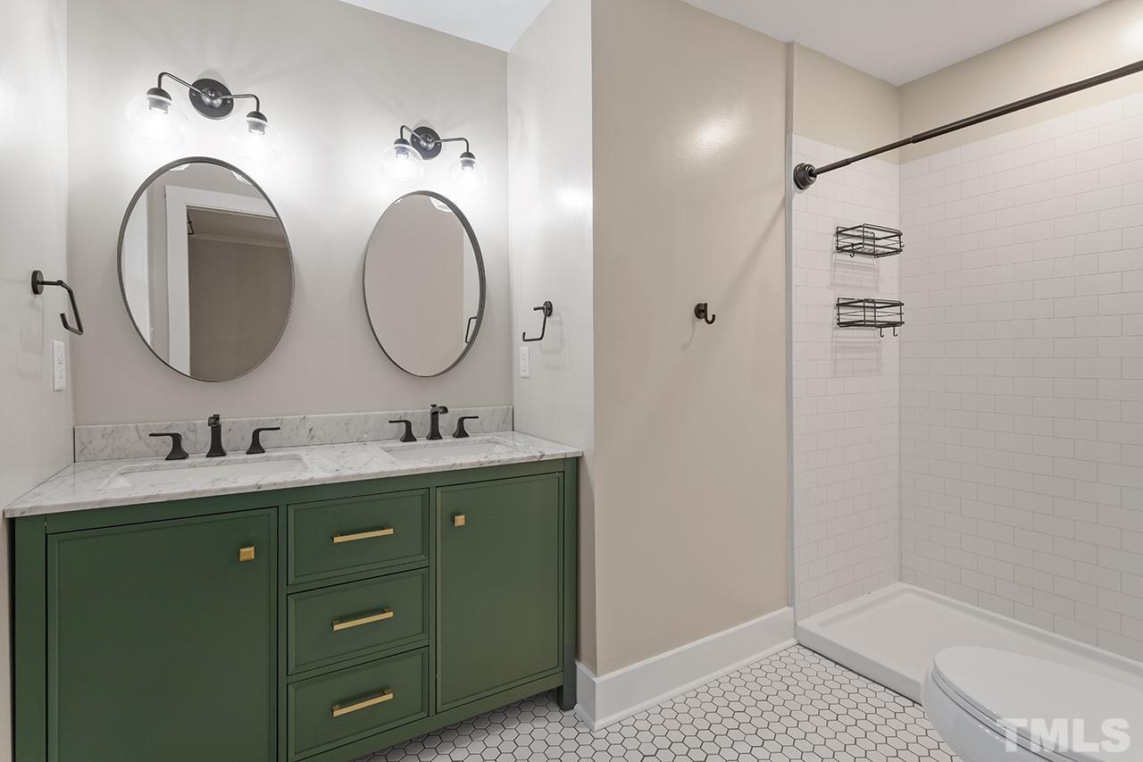2609 Elmhurst Circle Raleigh, NC 27610 - Photo 21 of 34 a bathroom with a granite countertop sink a mirror and shower