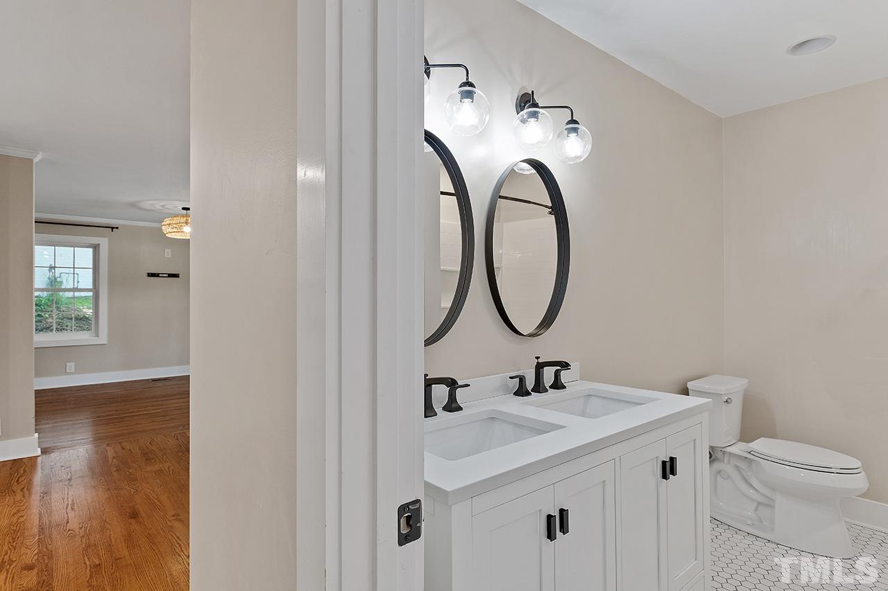 2609 Elmhurst Circle Raleigh, NC 27610 - Photo 25 of 34 a bathroom with a granite countertop toilet sink and mirror