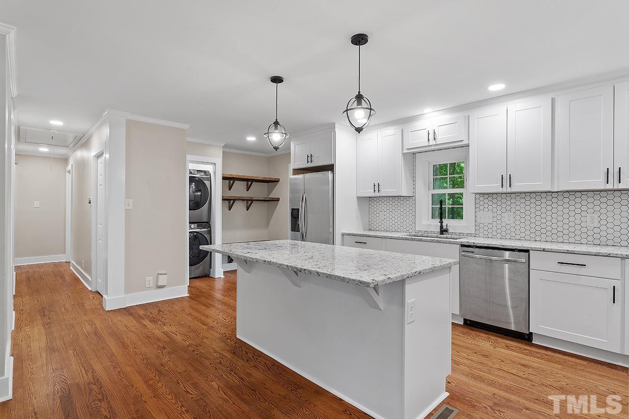 2609 Elmhurst Circle Raleigh, NC 27610 - Photo 8 of 34 a kitchen with stainless steel appliances granite countertop a sink a stove a refrigerator and island with wooden floor