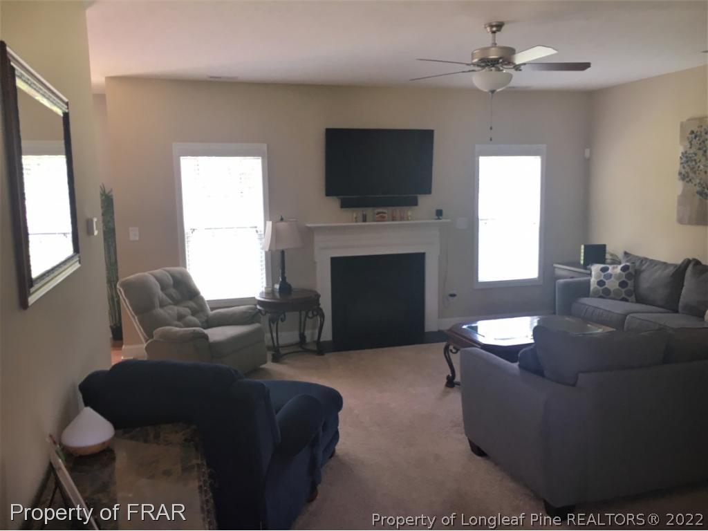 804 Raspberry Road Stedman, NC 28391 - Photo 4 of 34 a living room with furniture a fireplace and a flat screen tv