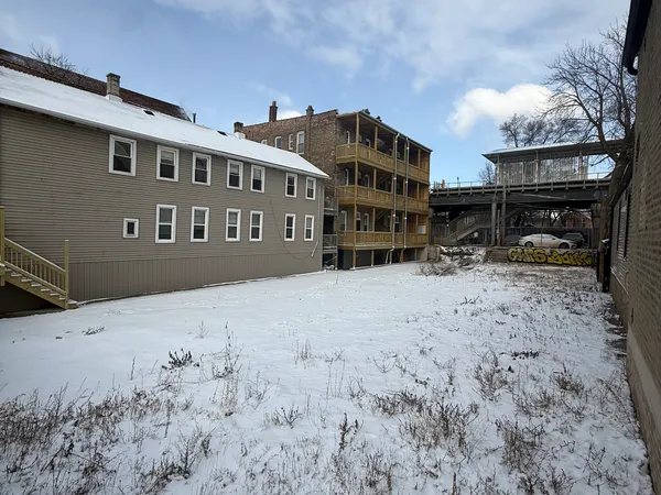 a view of a building with a yard covered with snow in the yard