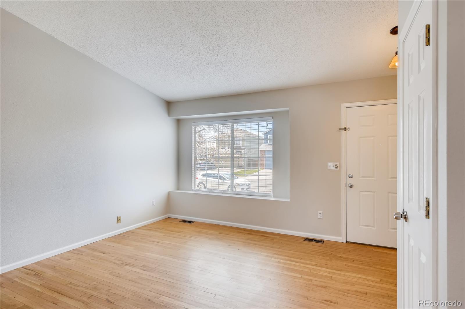 9684 South Castle Ridge Circle Highlands Ranch, CO 80129 - Photo 6 of 28 a view of an empty room with wooden floor and a window