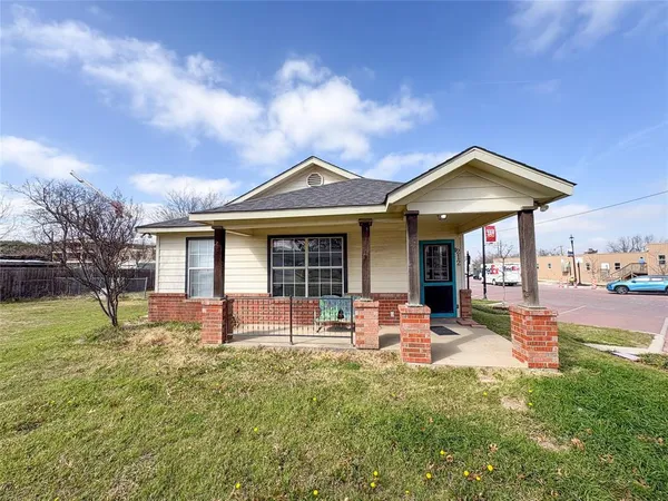 a front view of a house with a garden and trees