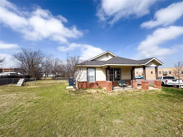a view of a house with a big yard and large tree