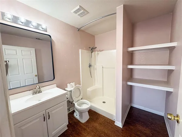 a bathroom with a sink a toilet a mirror and shower