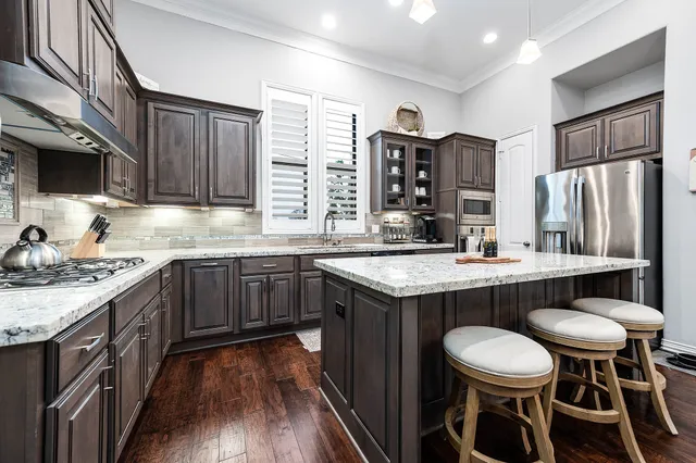 a kitchen with stainless steel appliances granite countertop a sink stove and cabinets
