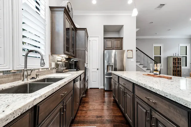 a kitchen with granite countertop a sink appliances and cabinets