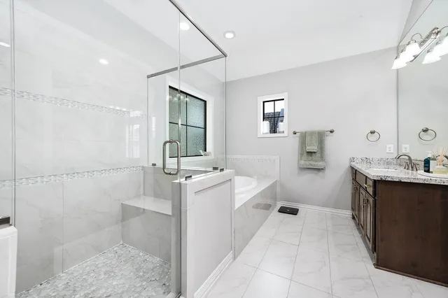 a spacious bathroom with a double vanity sink a mirror and a shower