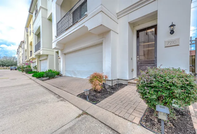 a vase of flowers sitting on a sidewalk