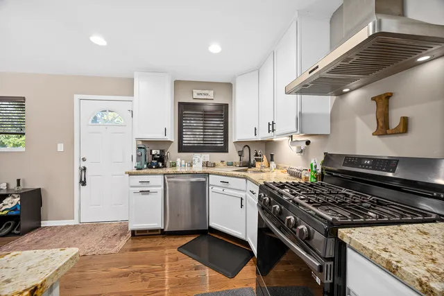 a kitchen with stainless steel appliances granite countertop a stove and a sink