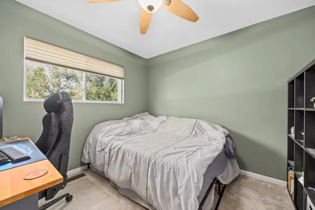 a bed sitting in a bedroom next to a window