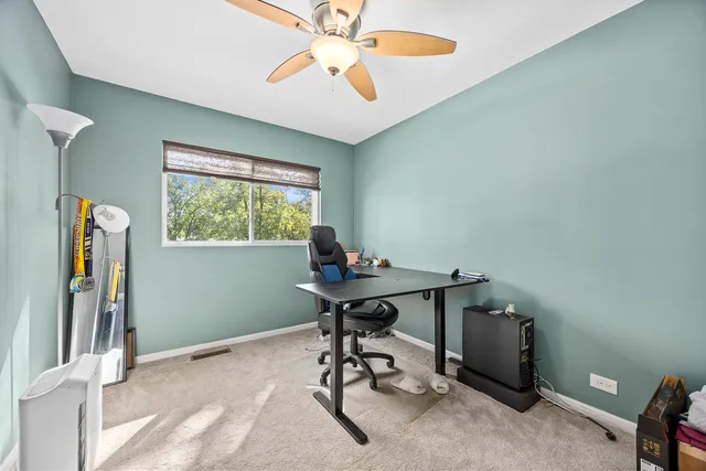 a view of a workspace with furniture and a window