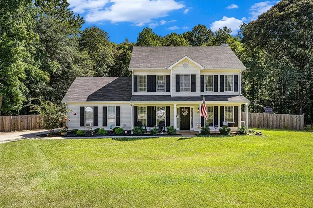 a aerial view of a house next to a big yard and large trees