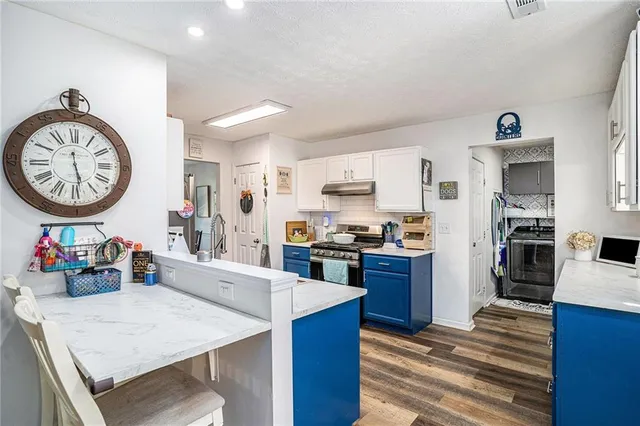 a kitchen with stainless steel appliances wooden floor dining table and chairs