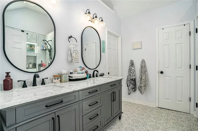 a bathroom with a granite countertop double vanity sink and a mirror