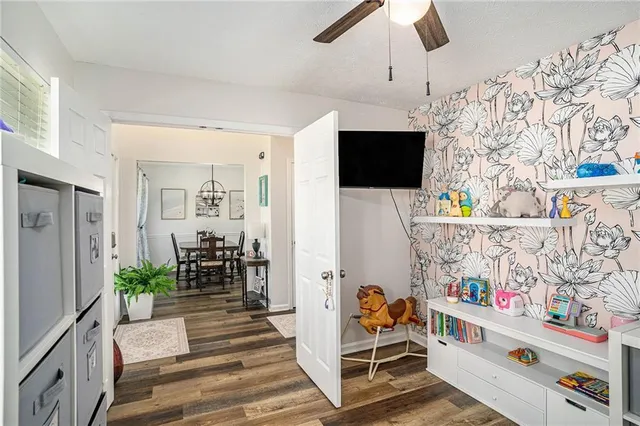en suite bathroom with a potted plant on the wall and a flat screen tv