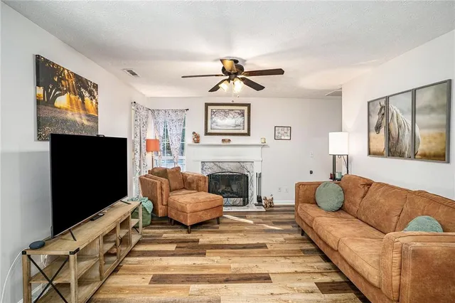 a living room with furniture a flat screen tv and a fireplace