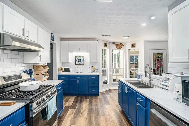 a kitchen with stainless steel appliances granite countertop a stove and a sink