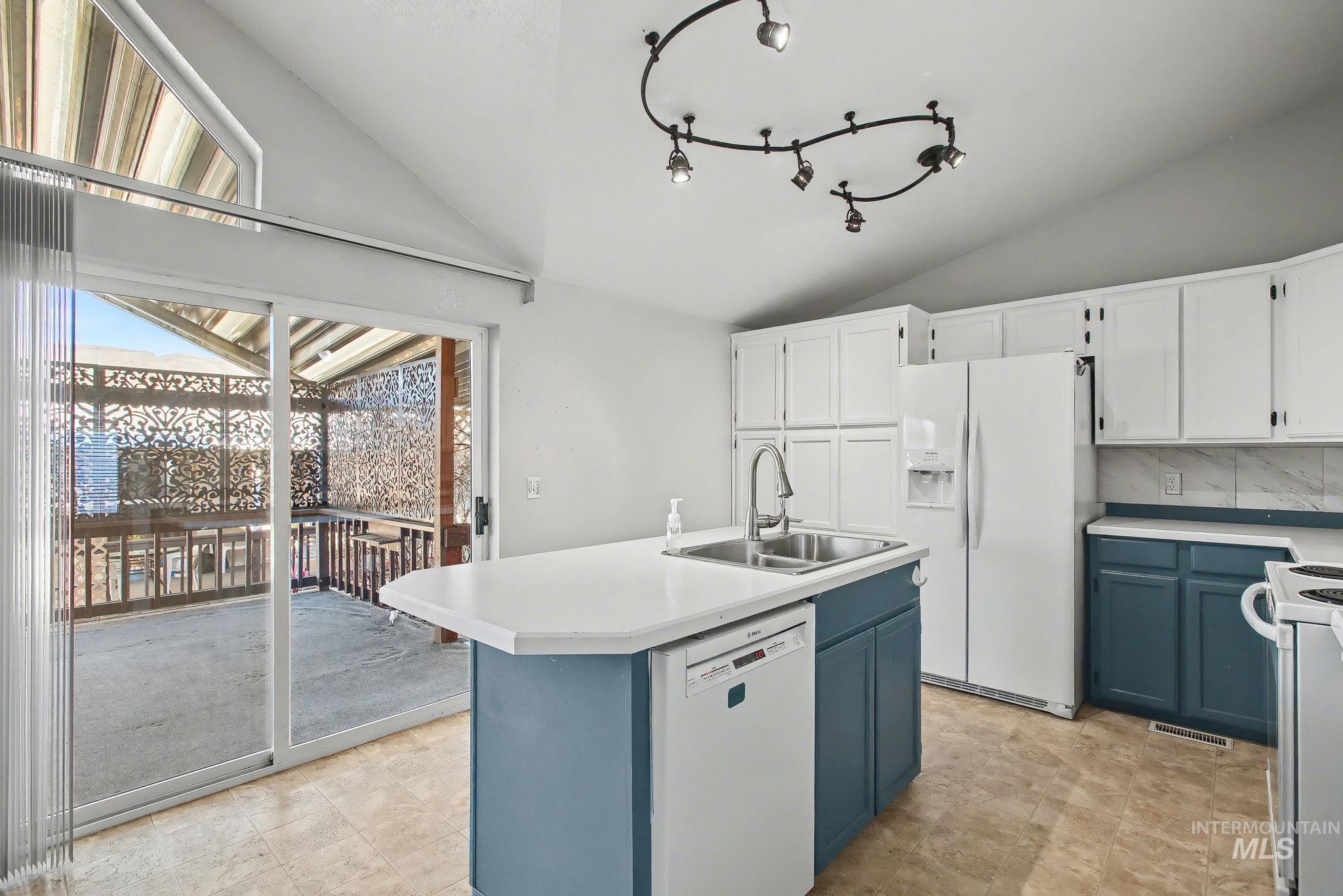 1430 Chestnut Street, Unit 28 Clarkston, WA 99403 - Photo 4 of 34 Kitchen featuring blue cabinetry, lofted ceiling, light countertops, white appliances, and white cabinets