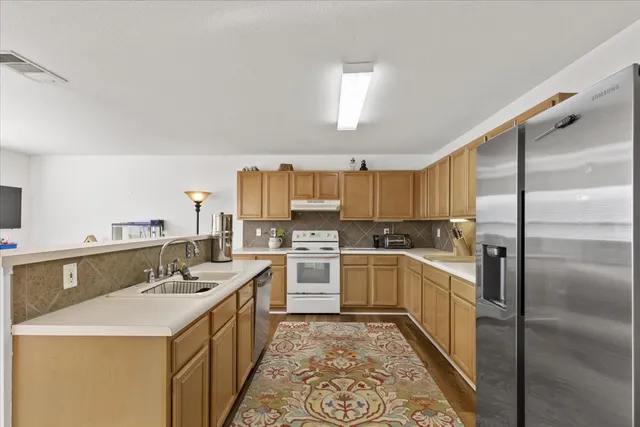a kitchen with a sink stove and refrigerator