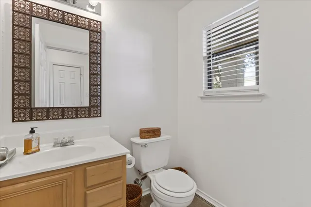 a bathroom with a granite countertop toilet sink and mirror