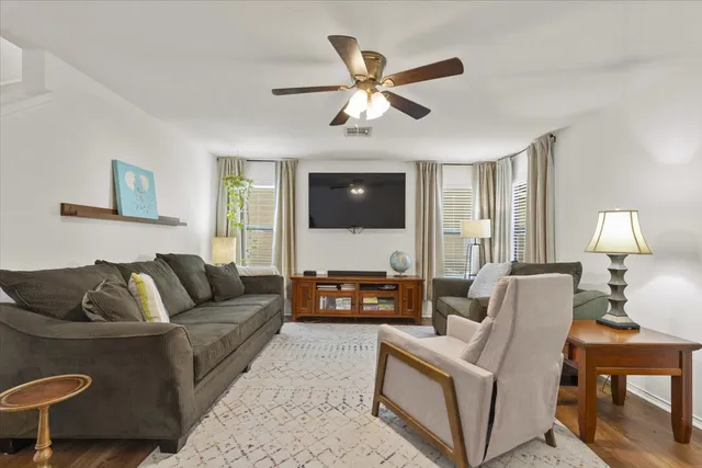 a living room with furniture ceiling fan and a window