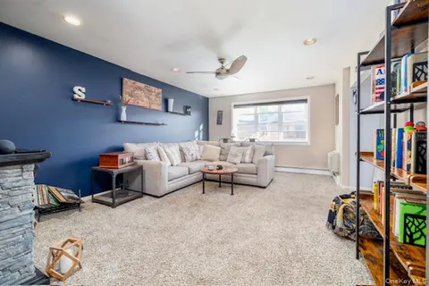 a living room with furniture a bookshelf and a window