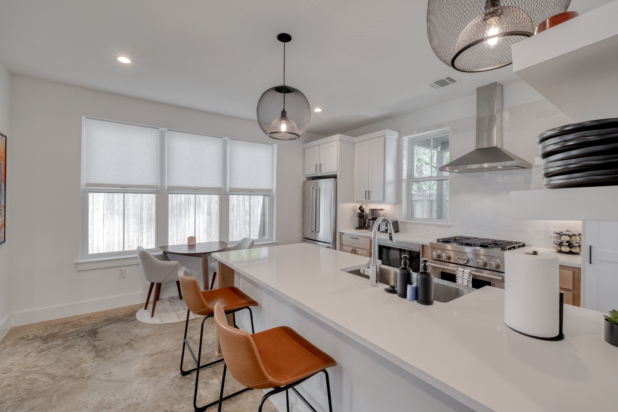 5406 Downs Drive, Unit 2 Austin, TX 78721 - Photo 3 of 24 a kitchen with stainless steel appliances granite countertop a stove a sink a dining table and chairs with wooden floor