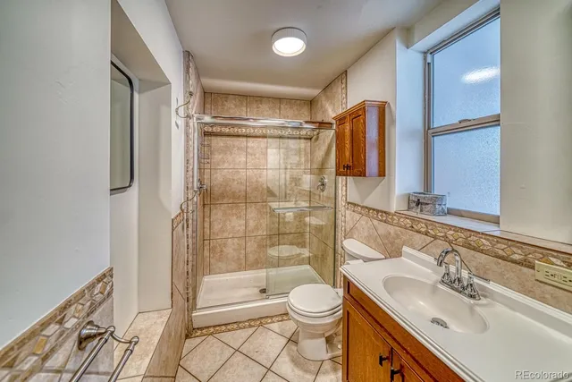 an empty room with wooden floor cabinet and windows