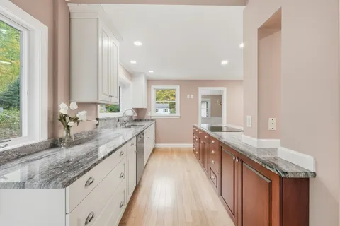 a bathroom with granite countertop a sink a large mirror and a window
