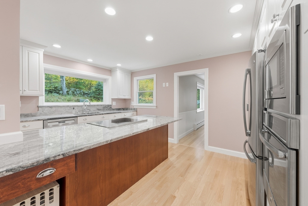 56 Century Mill Road Bolton, MA 01740 - Photo 12 of 41 a kitchen with stainless steel appliances granite countertop a sink and a wooden floors