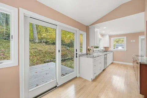 a open kitchen with white cabinets and wooden floors