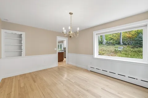 a view of a livingroom with wooden floor and a large window