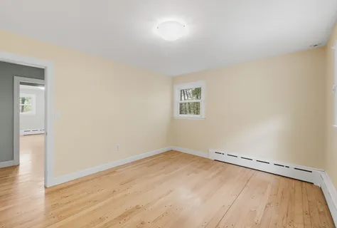 a view of a room with wooden floor and white walls