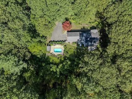 a aerial view of a house with a yard and large trees